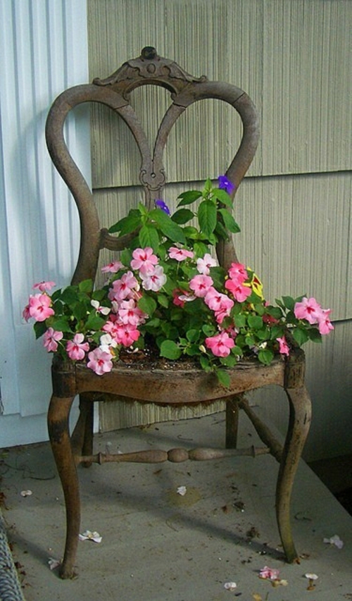Vanhat tuolit puutarhassa, jossa on uusi ominaisuus tuulettimella houkutteleva istutuskone