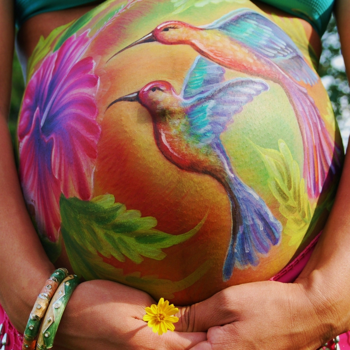 Peinture de ventre de bébé avec colibri