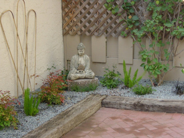 Figuras de Buda en el jardín borde verde remolacha grava