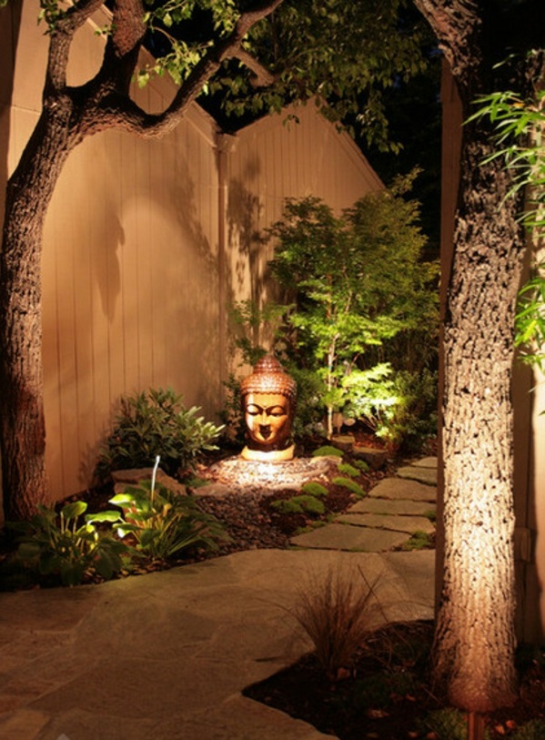 Figuras de Buda en la iluminación ambiental del jardín