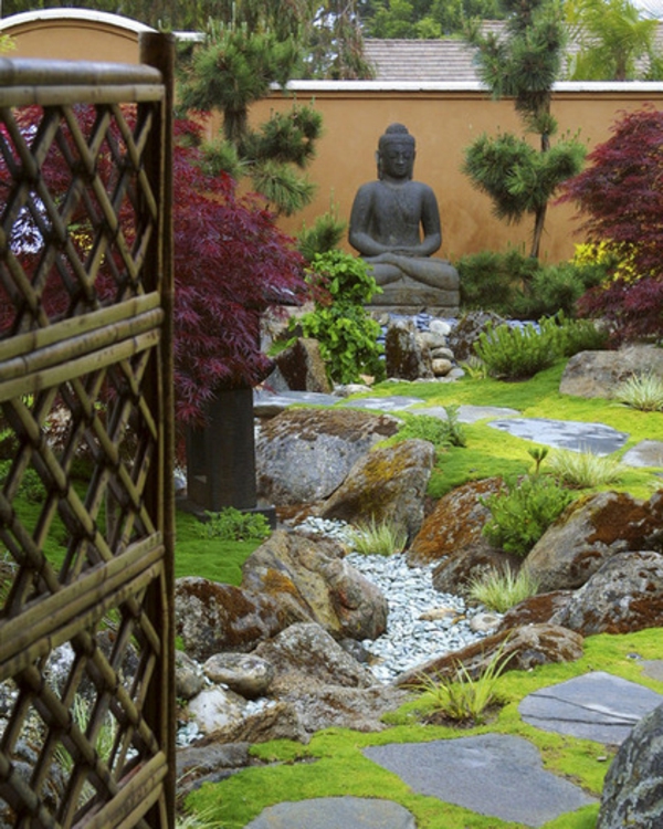 Figuras de Buda relajándose en el entorno verde del jardín