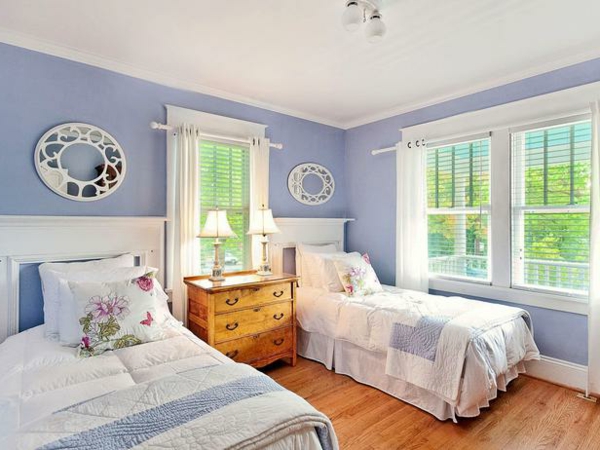 غرفة النوم مؤثثة بشكل مريح مع أسرّة مفردة مصممة من الجدار الأزرق