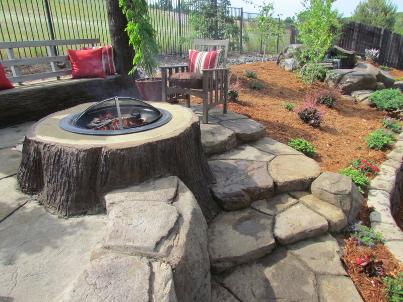 Estructura de pozo de fuego con diseño de jardín de tronco de árbol con esquina acogedora piedras