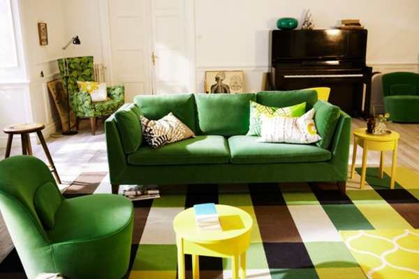 Žalios dizaino sofos dažytos lakuotais geltonais išmatomis