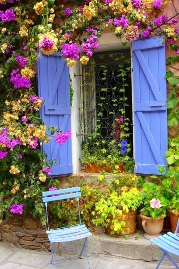 hek deuren mediterrane tuin houten stoelen blauw metaal