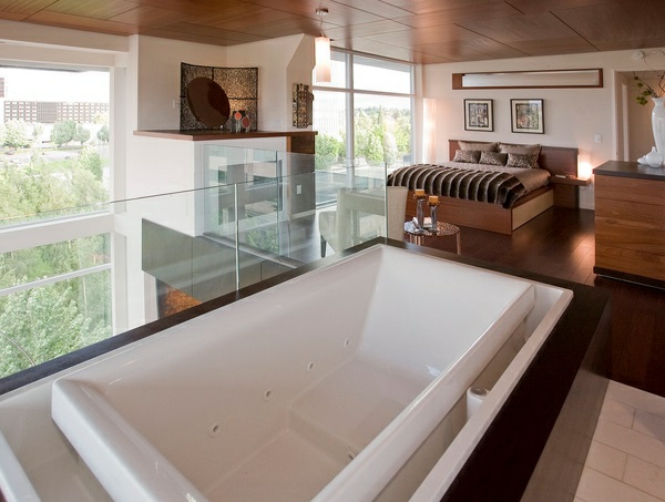 El diseño romántico ve la bañera en el vidrio de barandilla del dormitorio