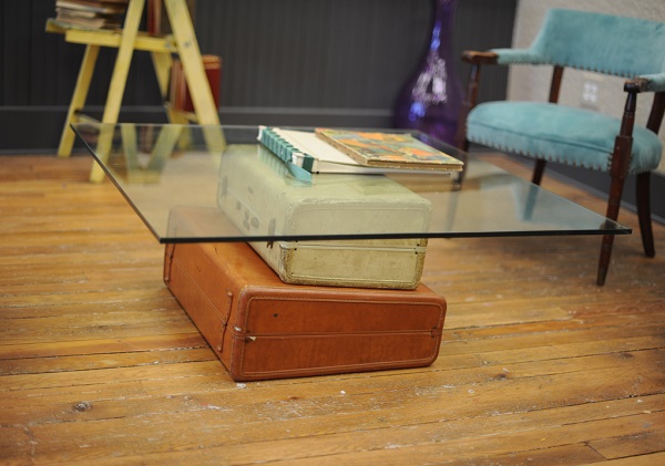 Los muebles de moda hechos de viejas maletas hacen que la superficie del vidrio de la mesa