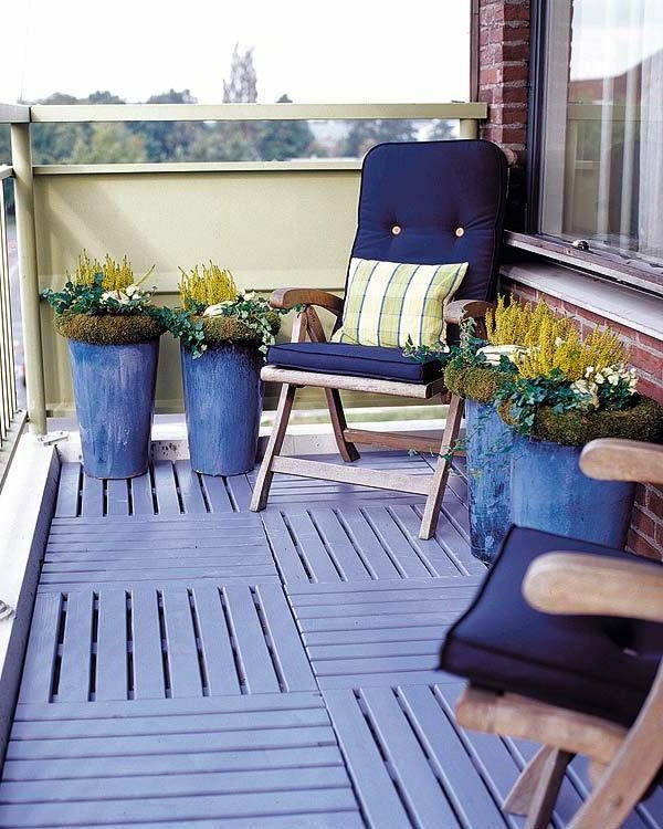 balkony nápady dřevěné dlaždice světle modré květy hrnce sedáky polštáře