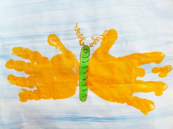 дрънкане с деца красива пеперуда, направена от жълти ръчни отпечатъци