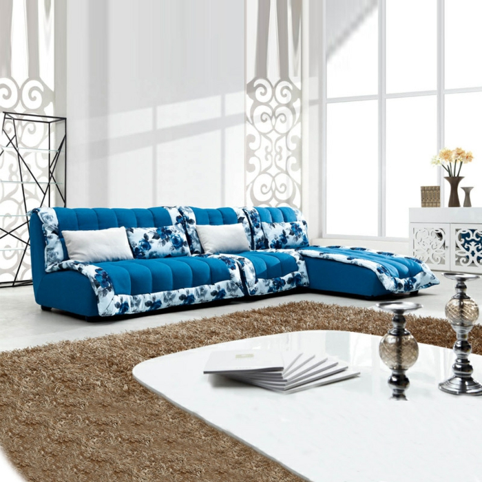 modrá pohovka květinové ozdoby minimalistický konferenční stolek béžový koberec