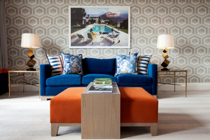 blauwe sofa oranje kruk licht tapijt geometrisch behang