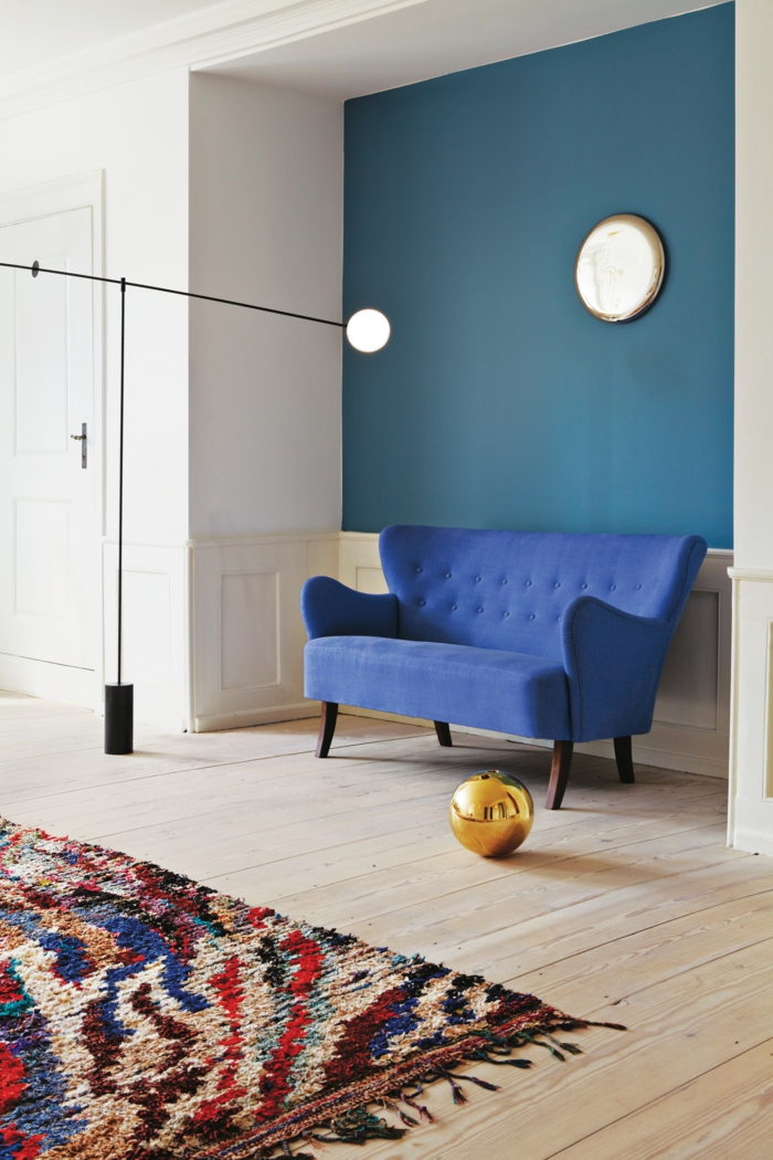 modrá pohovka retro pohled barevný koberec dřevěný koberec