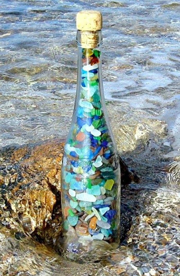 Les bouteilles de décoration remplissent les pierres colorées