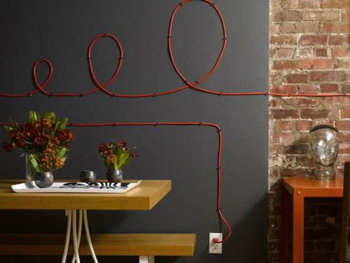 apdailos idėjos kūrybinis kabelis ant sienos pasislėpęs raudonai