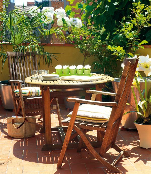 balcony set up wooden furniture pillows plant