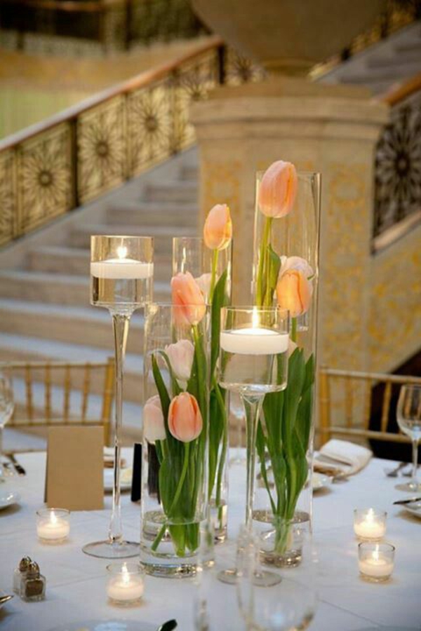 elegant borddekorasjon med tulipaner lys glass vaser full av vann