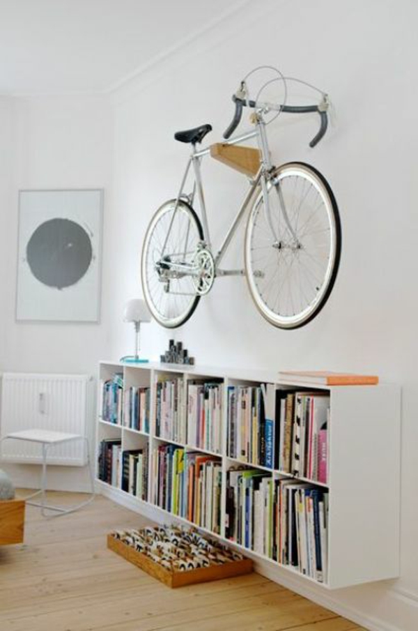 Επιτοίχια βάση ποδηλάτου κρέμεται σε μικρή βιβλιοθήκη