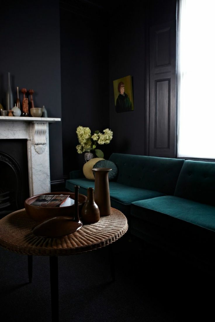 kleurstelling woonkamer zwarte muren donkergroene sofa ronde salontafel