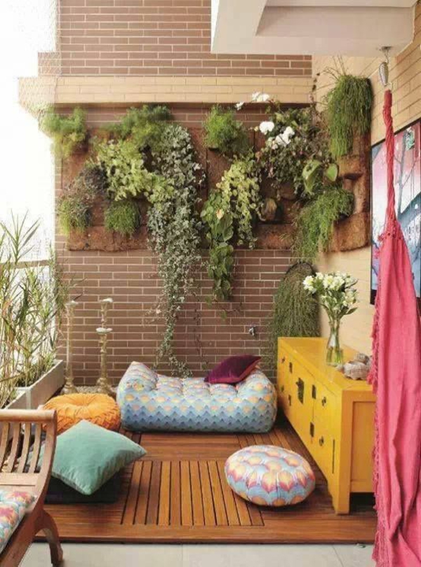 gekleurd terras design ideeën houten tegels tafel verticale tuin zitkussens