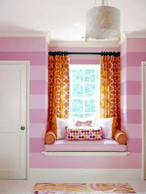 坐在地区的孩子房间粉红色条纹墙