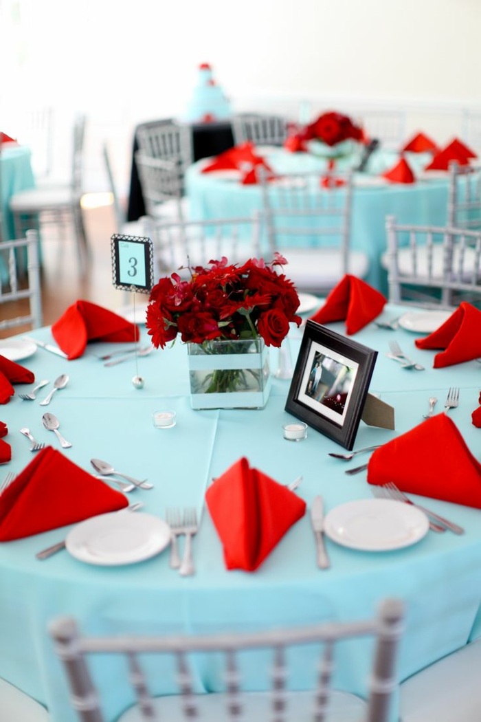 juhlava pöydän koristelu vaaleansininen pöytäliina punaiset lautasliinat