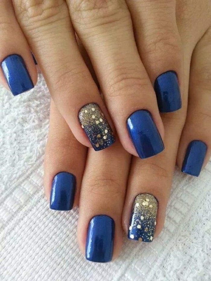 diseño de uñas azul dorado acentos
