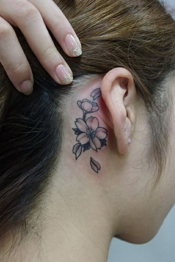 το τατουάζ των γυναικών πίσω από το μοτίβο λουλουδιών αυτιού
