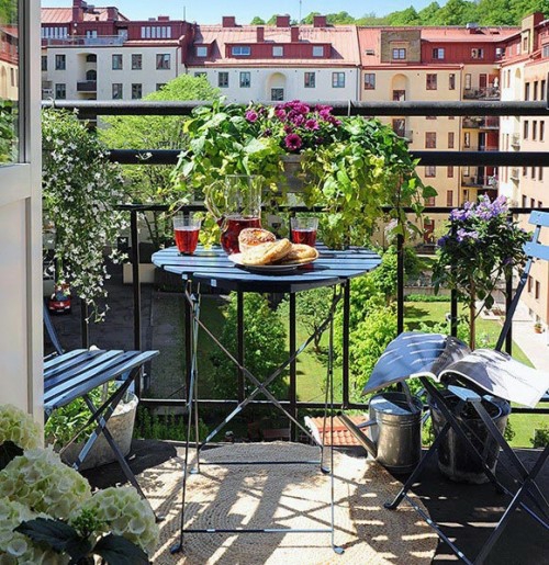 hyggelige balkon design lænestole sort metallisk runde bord blomsterkrudt blomsterpotter