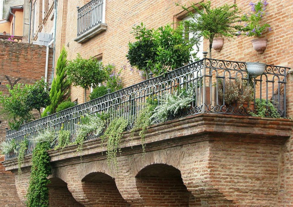 Kabantys sodai ant balkono formos plytų sienos