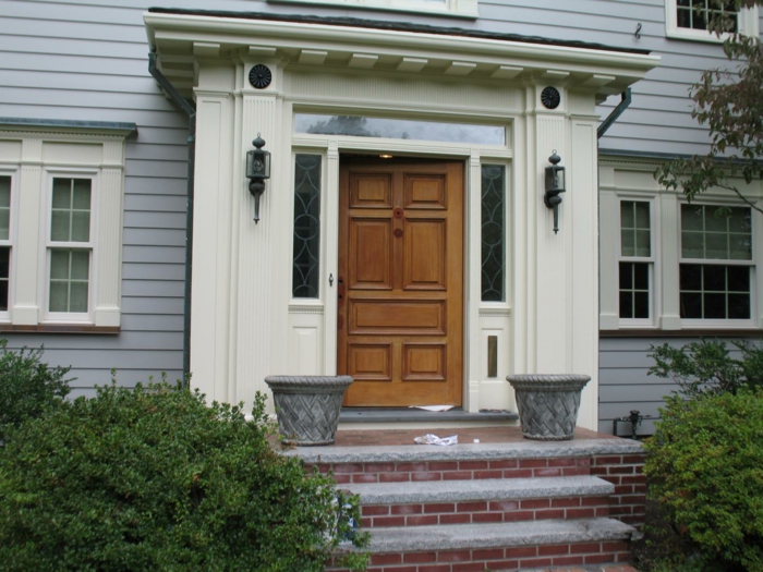 Вътрешната дървена врата на предната врата създава блестящ вход в контекста