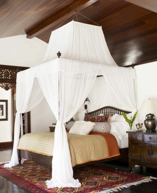 houten plafond donker bed matras beddengoed kussens tapijt