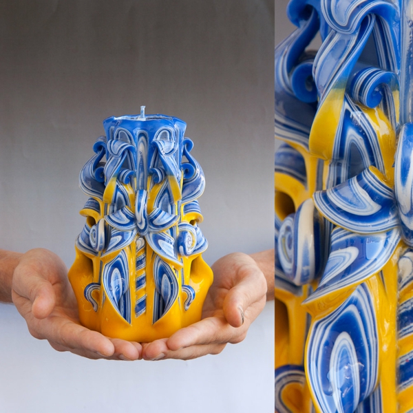 Las velas en sí mismas hacen una vela tallada azul amarilla