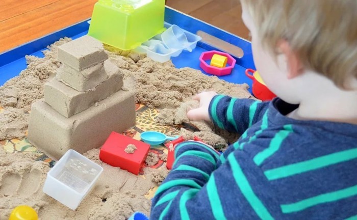 يلعب الطفل مع الرمال الحركية لجعل نفسك