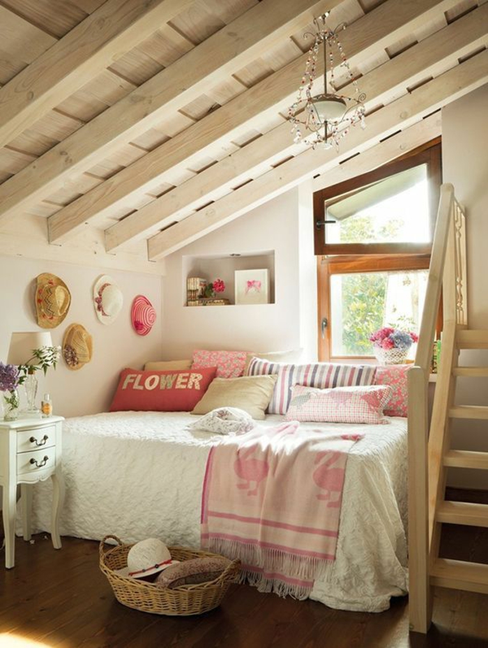 Vaikų kambarys su nuolydžiu stogo skersine medine siena dekoruota skrybėlėmis pintinė lova senovinių nakvynės namų stiliaus