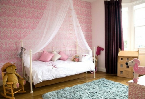 Kinderkamer roze muren hemelbed meisje speelgoed zacht tapijt
