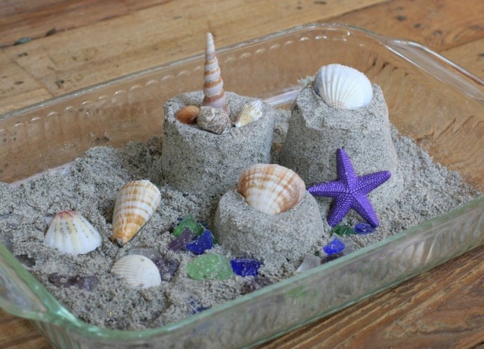Kinetic sand in the casserole dish with mussels and snails