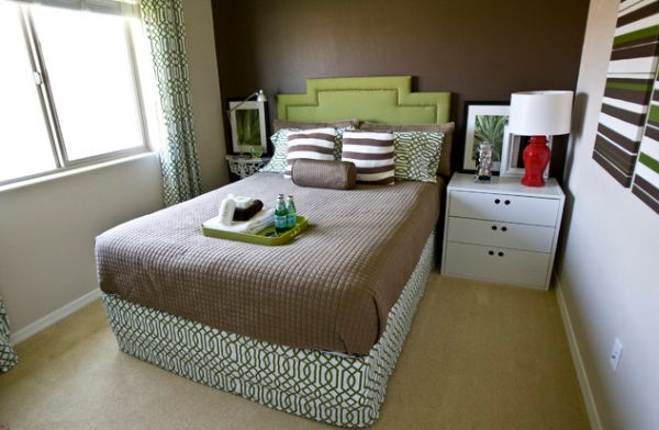 小卧室创造性地框架狭窄的双人床，草绿色床头板