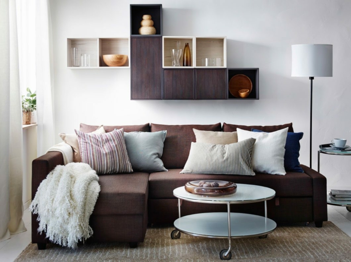 lille stue sæt brune sofa væg hylder firkantet træ runde sidebord
