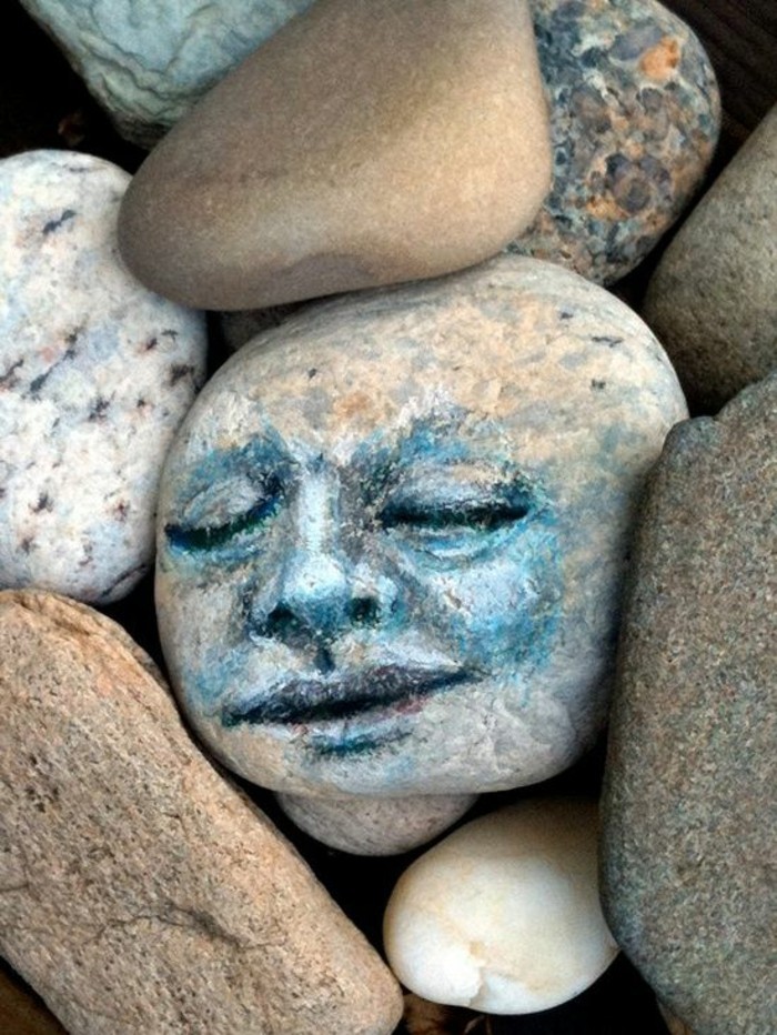 Ζωγραφική τέχνη με πέτρες πρόσωπο στο ογκόλιθο