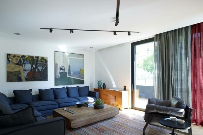 lamper stue belysning ideer mørk blå sofa træbord stribet tæppe væg dekoration