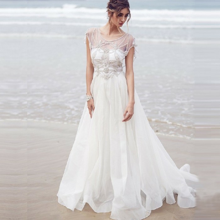 ilga boho stiliaus vestuvių suknelė balta nuotaka paplūdimyje
