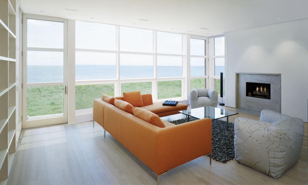 minimalistinen merimaisema oranssi nahkasohva lasipöytä