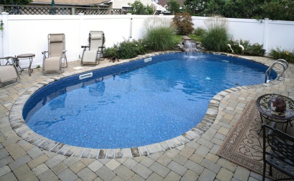 pool in the garden kidney-shaped garden furniture sunbed waterfall sitting area