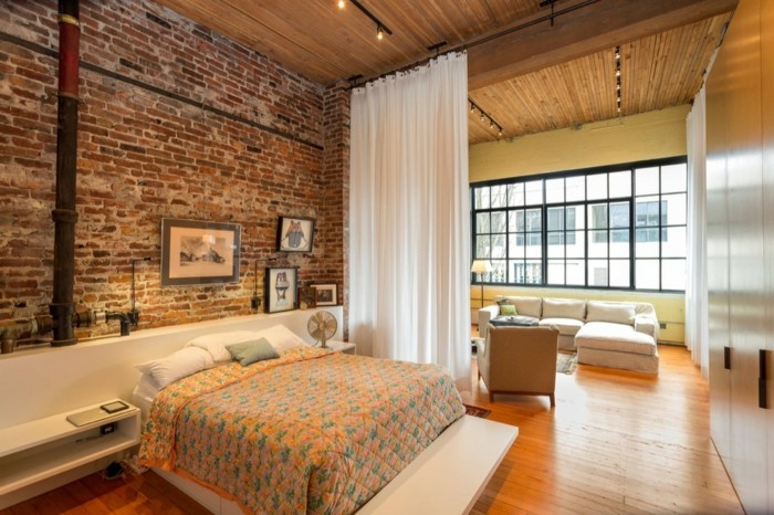 Miegamasis su šiltomis spalvomis įrengtas plytų sienos ir šviežios lininės