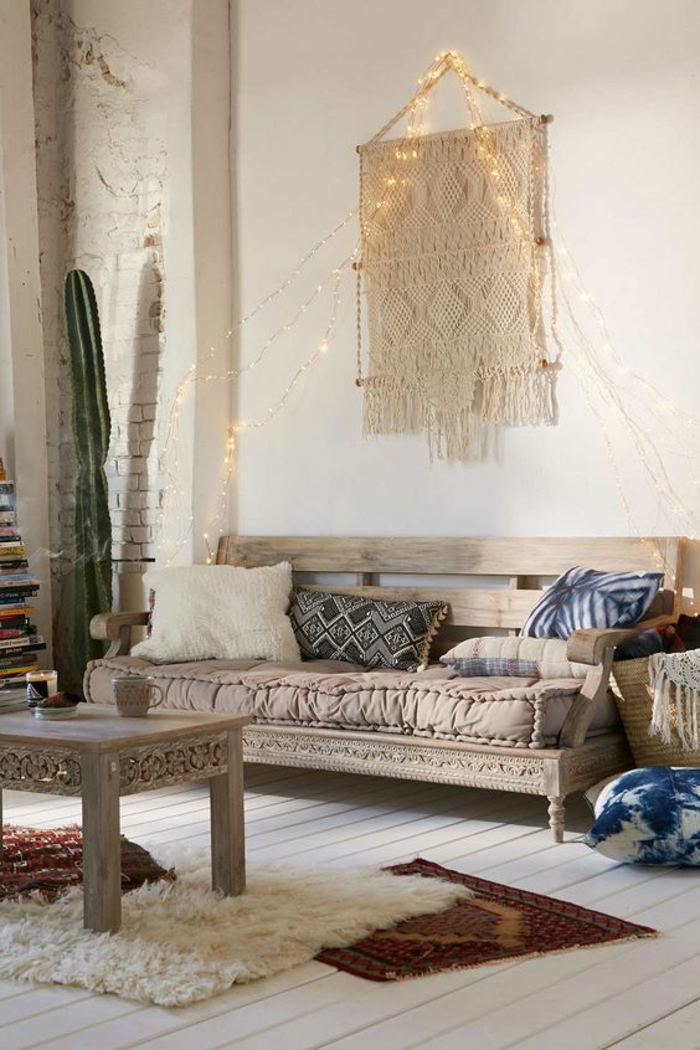 nuhjuinen tyylikäs huonekalu boho-tyyli puuhuivi makrame tyyny etno-matot lampaanpuutavara puulattiat string-valot sohva