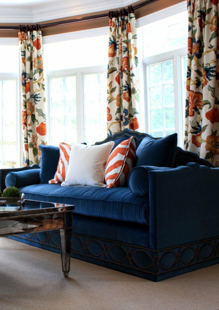 Canapé bleu rideaux colorés jeter oreillers tapis orange accents