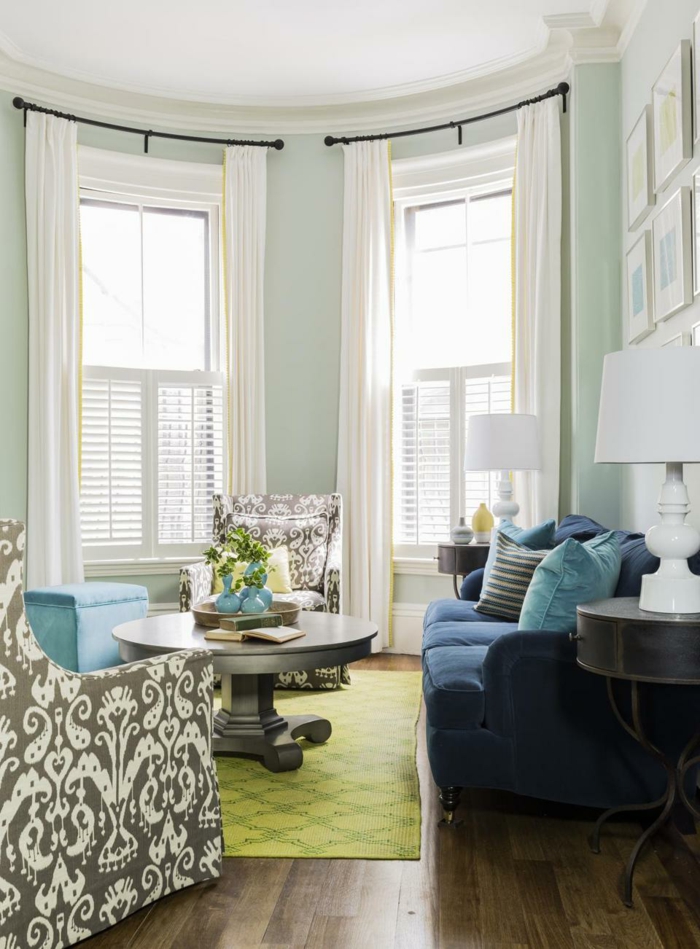 sofá alfombra verde azul piso de madera flores brillantes cortinas