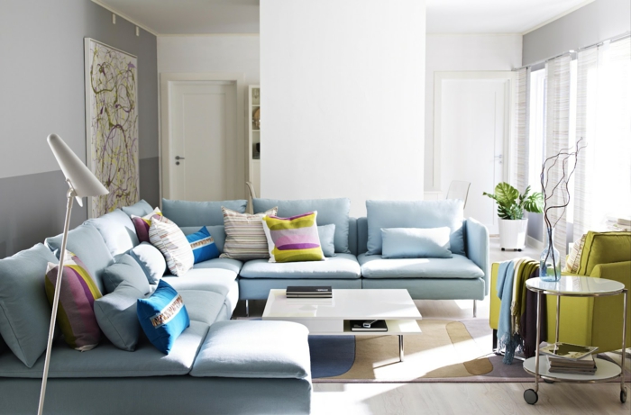 sofa blå lyseblå farget kaste pute grønne lenestol neutrale vegger