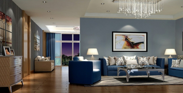 pohovka modrá obývací pokoj svícny koberec světle šedé stěny