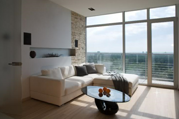 stenen muur woonkamer ovale salontafel panoramisch raam